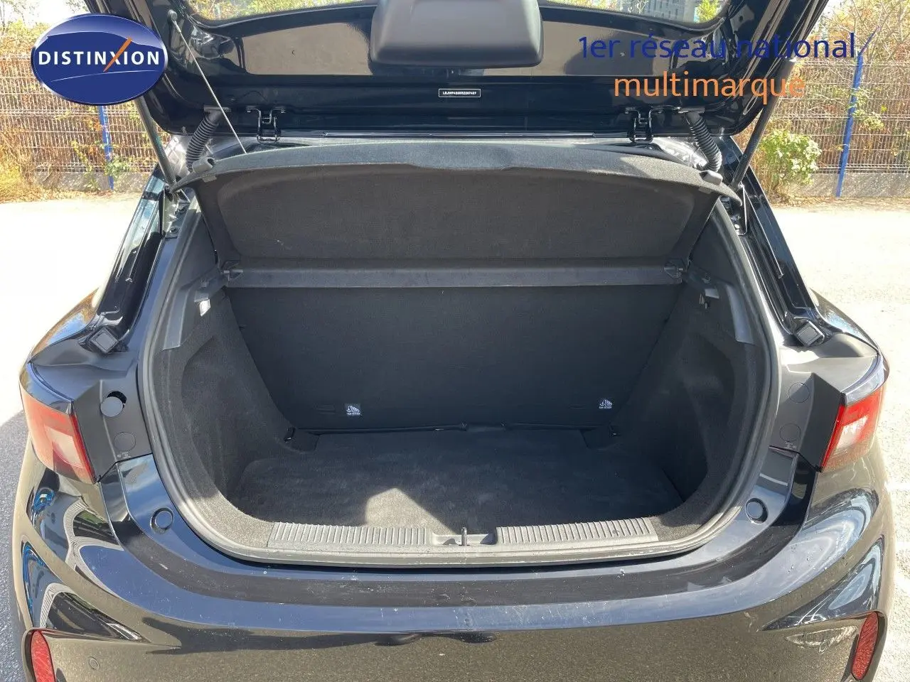 Coffre ouvert vu de l'arrière d'une MG3 1.5L Hybrid+ 2024 en Pebble Black Metal, montrant l'espace de chargement vide.