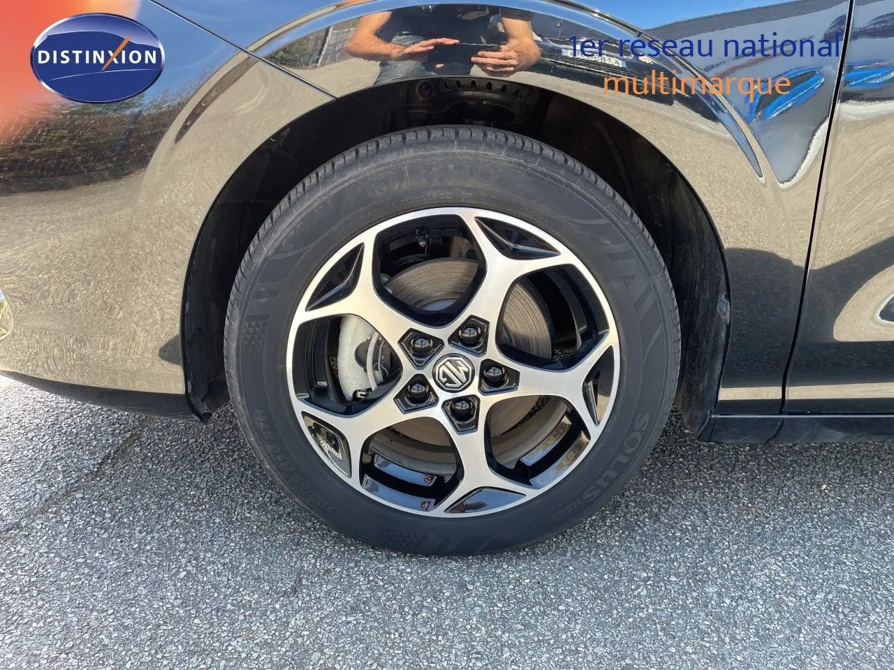 Gros plan sur la roue avant gauche d’une MG3 2024 Pebble Black Metal, mettant en valeur la jante alliage bicolore au design moderne.