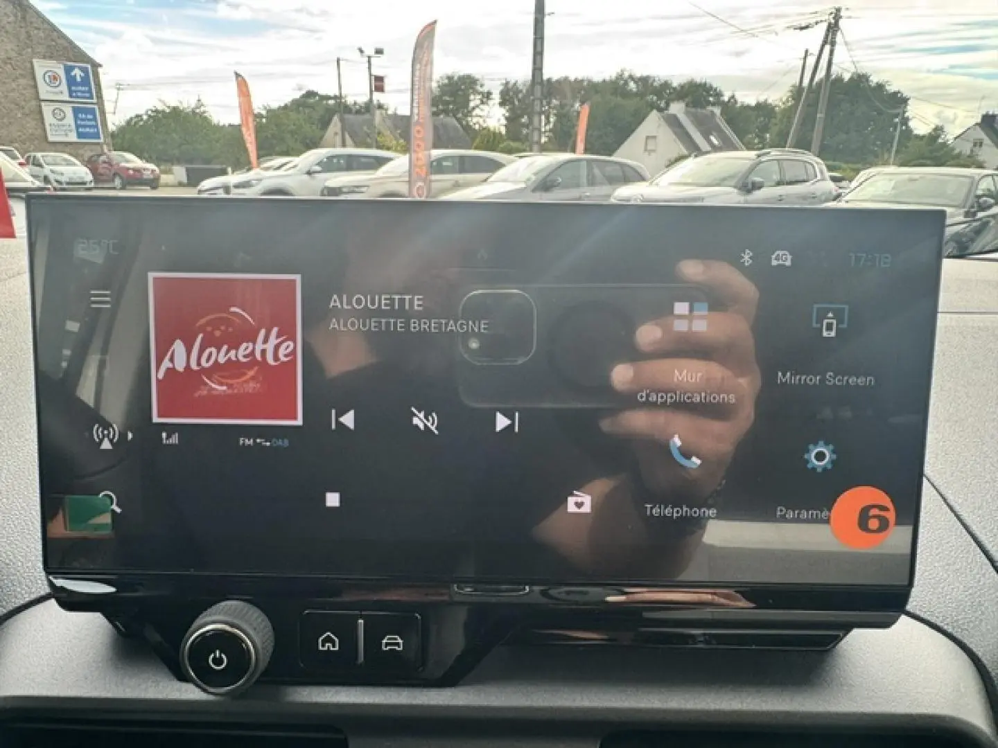 Écran tactile central du Citroën Berlingo gris acier, affichant la radio et commandes multimédia.