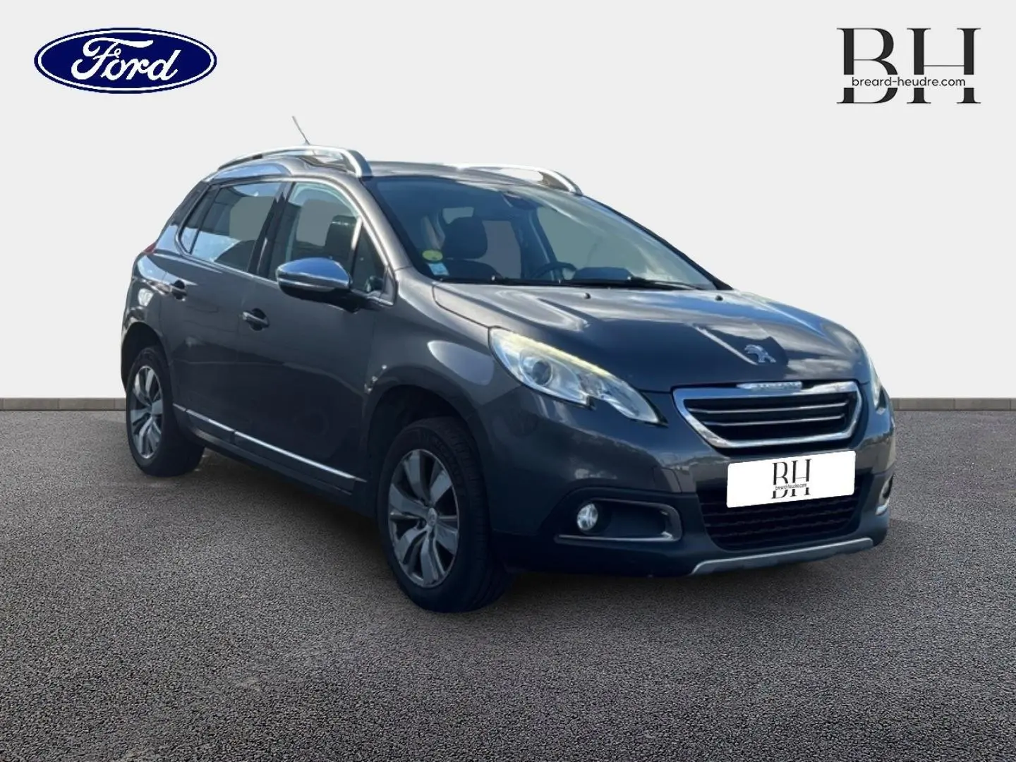 Peugeot 2008 diesel Spirit Grey en 3/4 avant droit, avec barres de toit et jantes alu visibles.