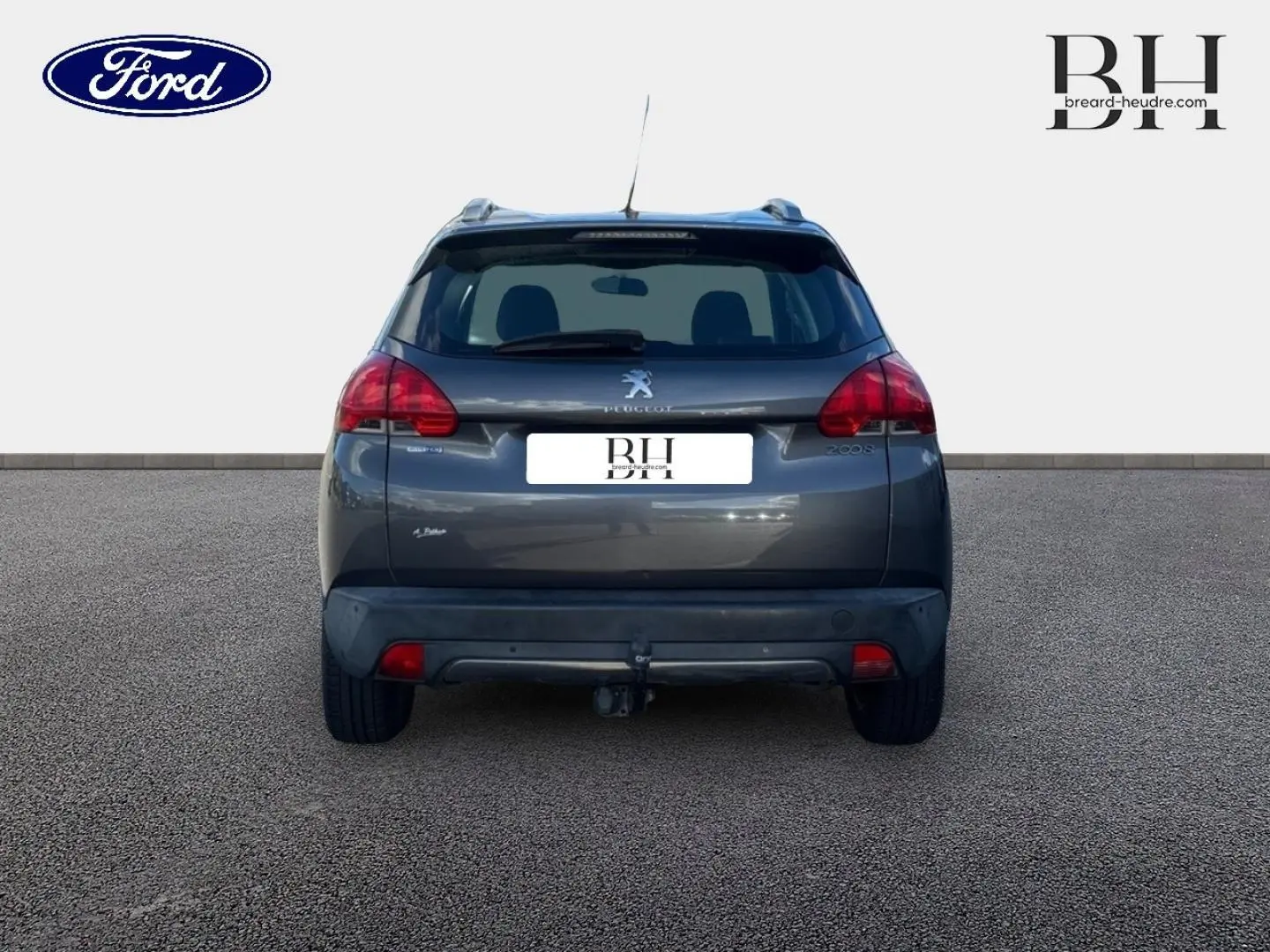 Vue arrière d’un Peugeot 2008 gris Spirit avec attelage, feux arrière rouges et toit noir.