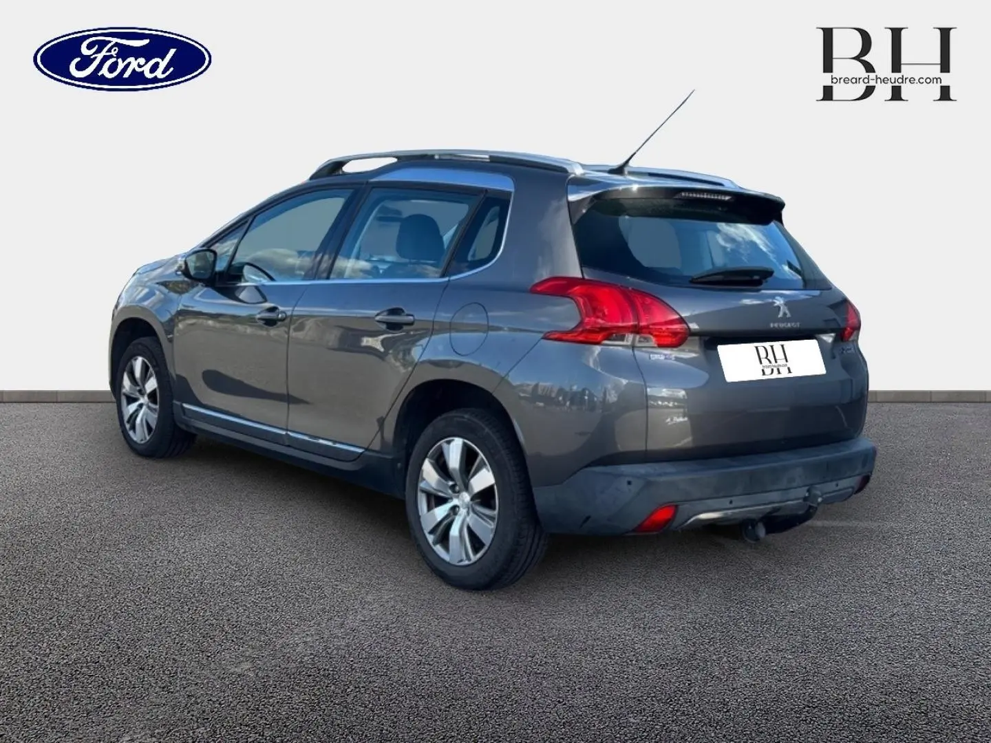 Peugeot 2008 Spirit Grey vue 3/4 arrière droit, avec barres de toit et jantes alu visibles.