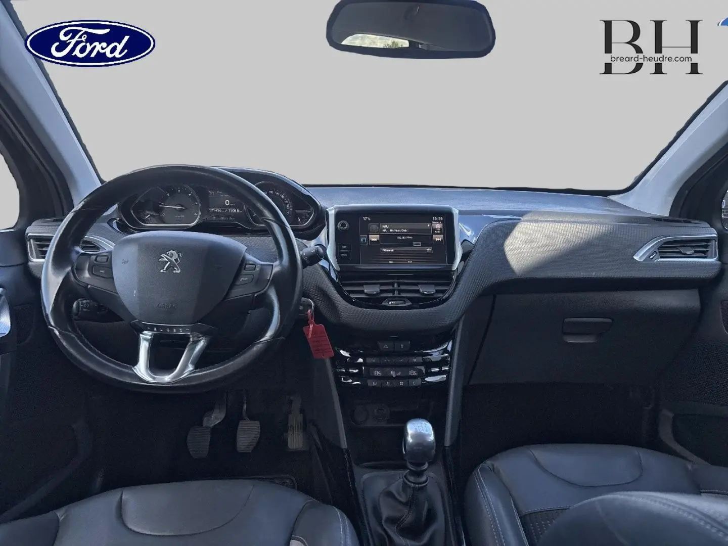 Vue intérieure avant du Peugeot 2008 2015 avec tableau de bord noir et volant cuir multifonction.