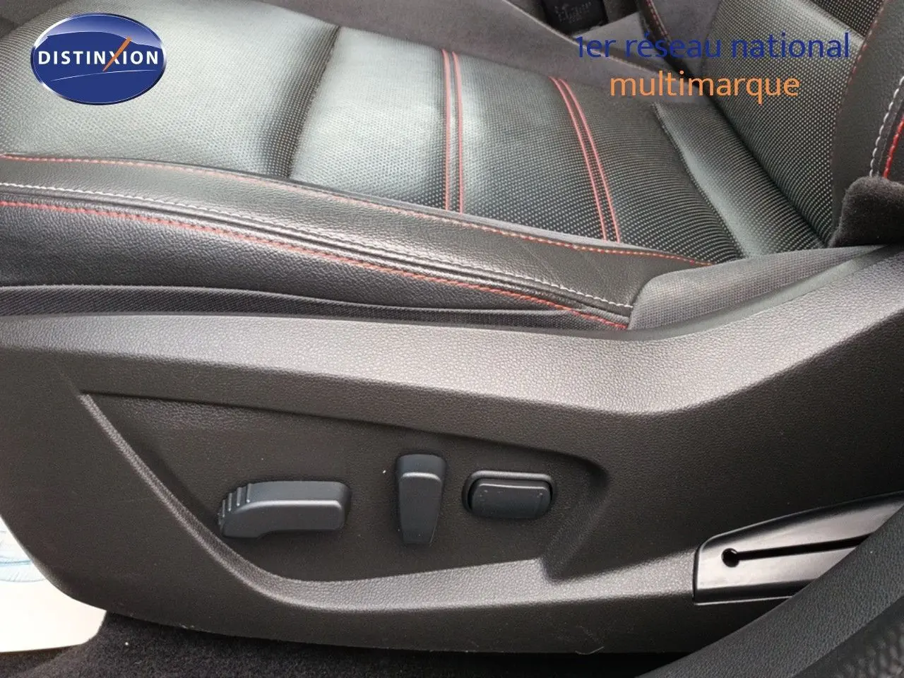 Gros plan sur les commandes électriques du siège en cuir noir avec surpiqûres rouges du Renault Arkana 1.6 E-TECH RS Line.