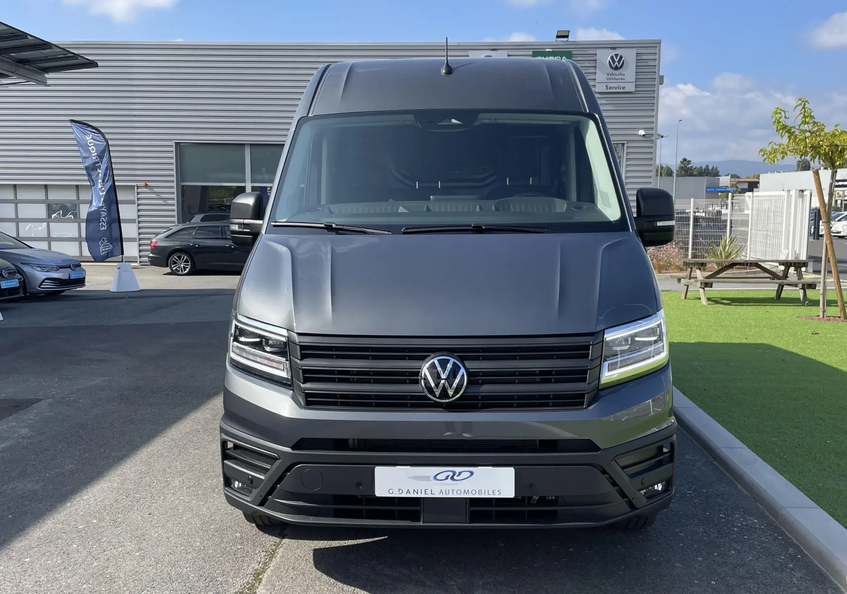 Vue frontale d'un Volkswagen Crafter Van gris Indium 2025 avec phares LED et calandre noire.