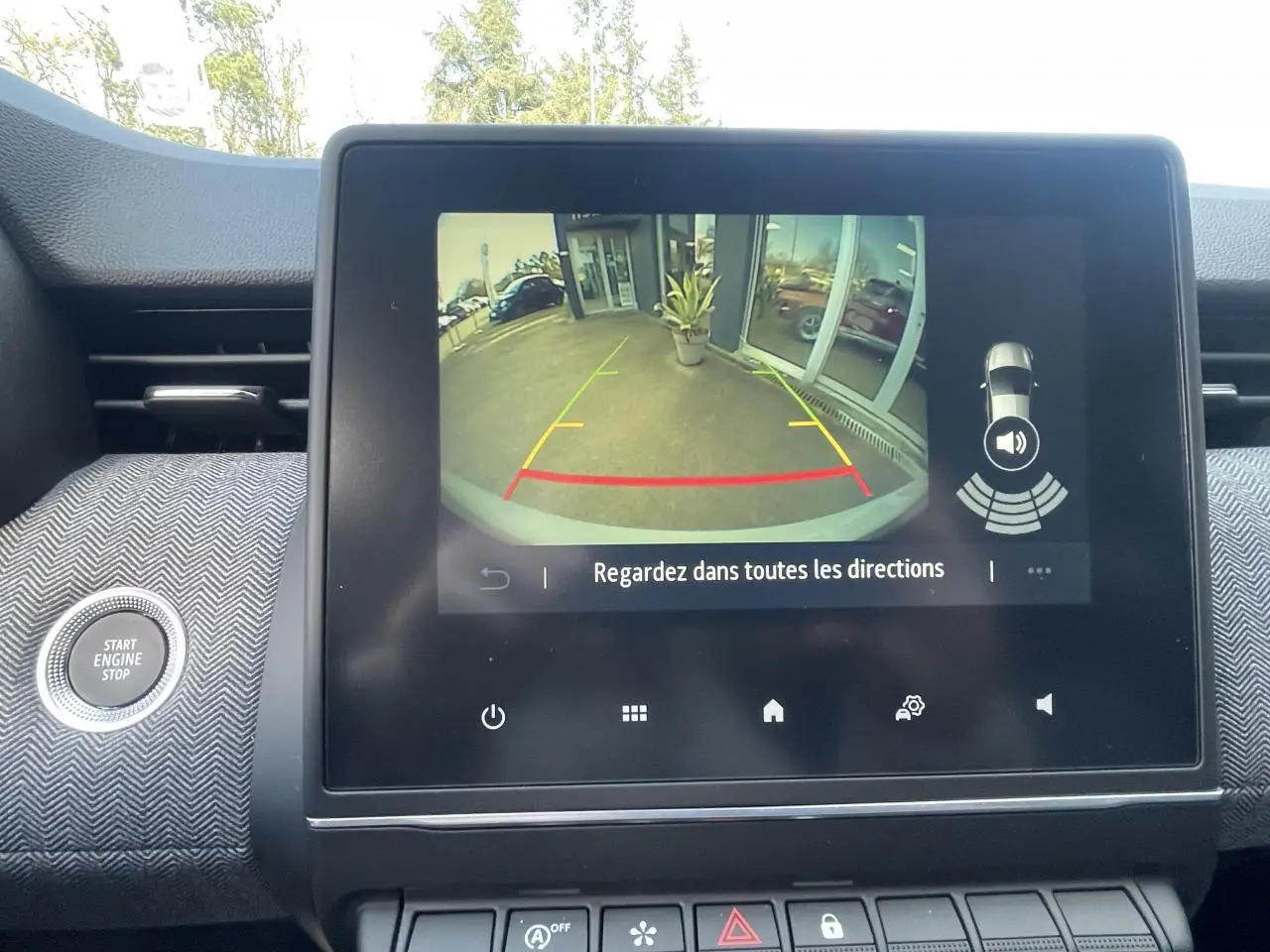 Écran multimédia affichant la caméra de recul de la Renault Clio Gris Rafale avec guidage de stationnement visible.
