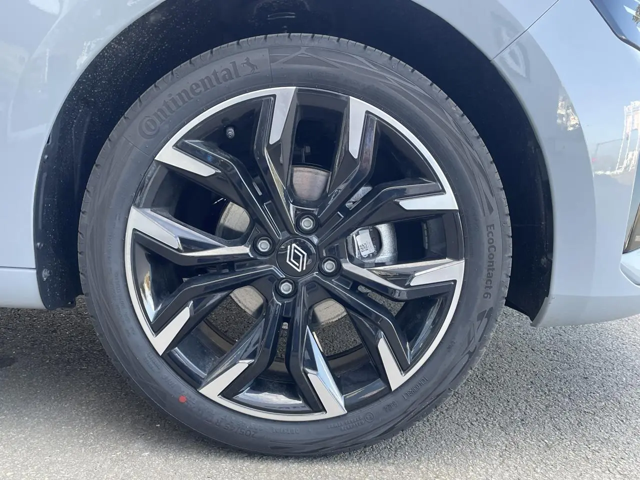 Gros plan sur la jante alliage diamantée 17 pouces noire et argentée du côté avant droit d'une Renault Clio Gris Rafale.