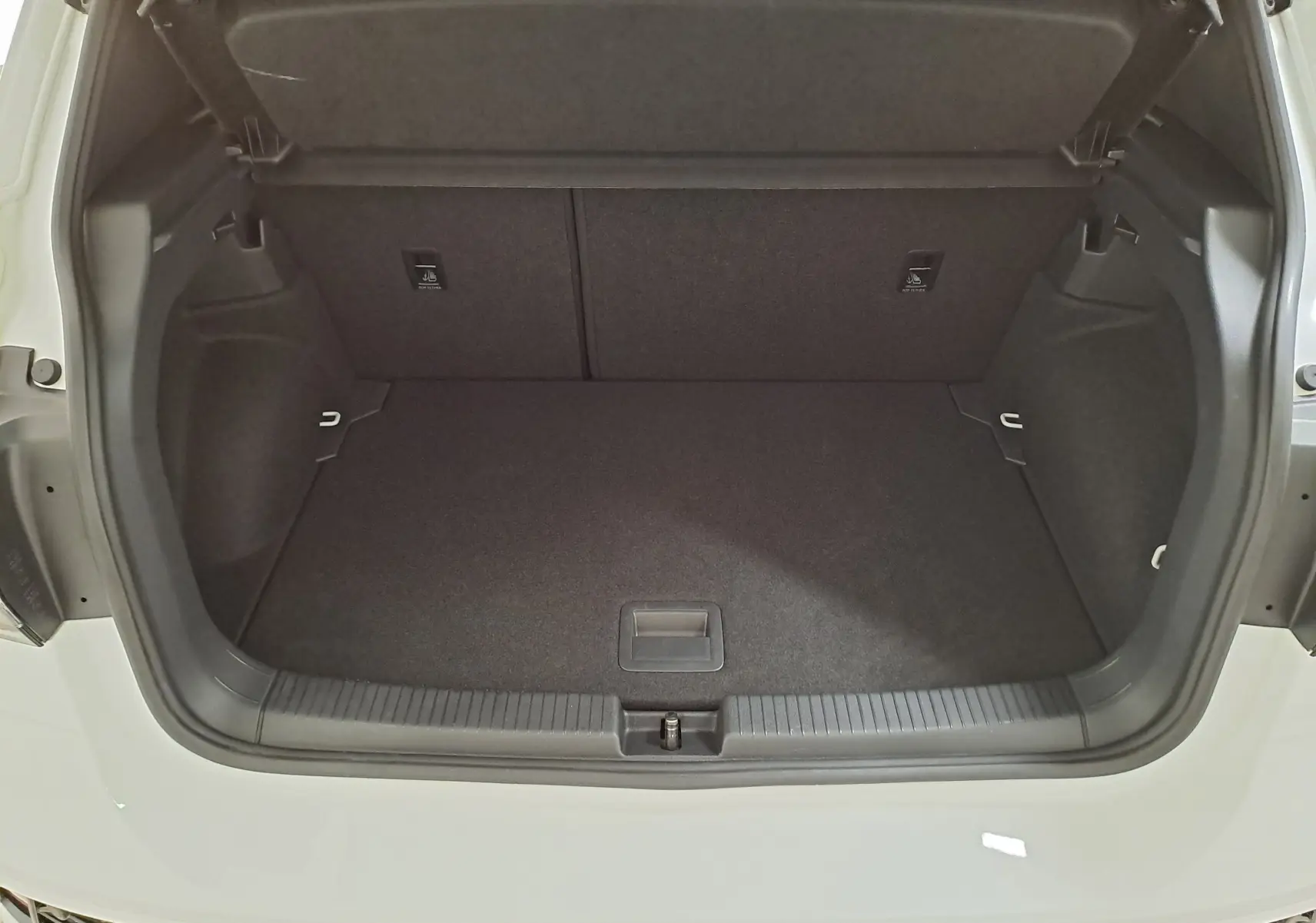 Coffre ouvert vu de l'arrière d'un Volkswagen T-Cross blanc pur 2025, version R-Line Edition, montrant l'espace de chargement vide.