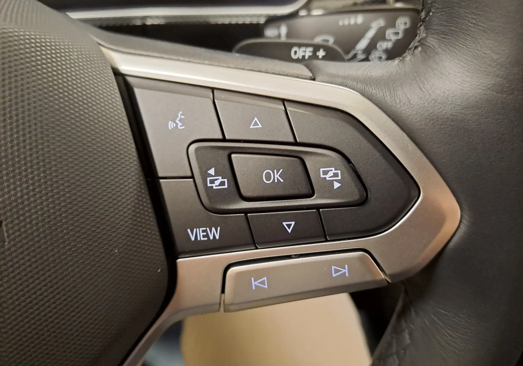 Gros plan sur les commandes du volant côté gauche du Volkswagen T-Cross blanc Pur 2025, version R-Line Edition.