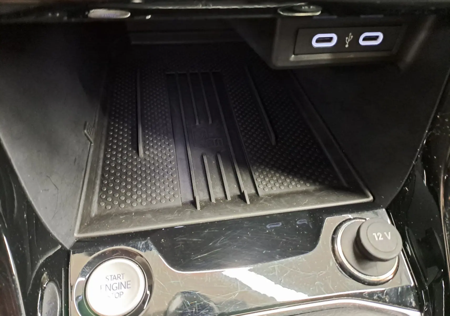 Détail de la console centrale du Volkswagen T-Cross blanc 2025, avec bouton start/stop, prise 12V et ports USB visibles.