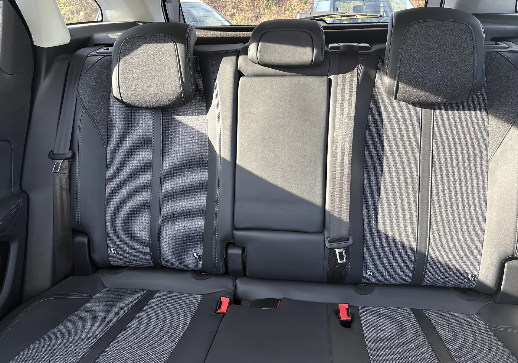 Vue intérieure sur la banquette arrière du Peugeot 3008 2019, tissu gris et cuir noir avec appuie-têtes et ceintures visibles.