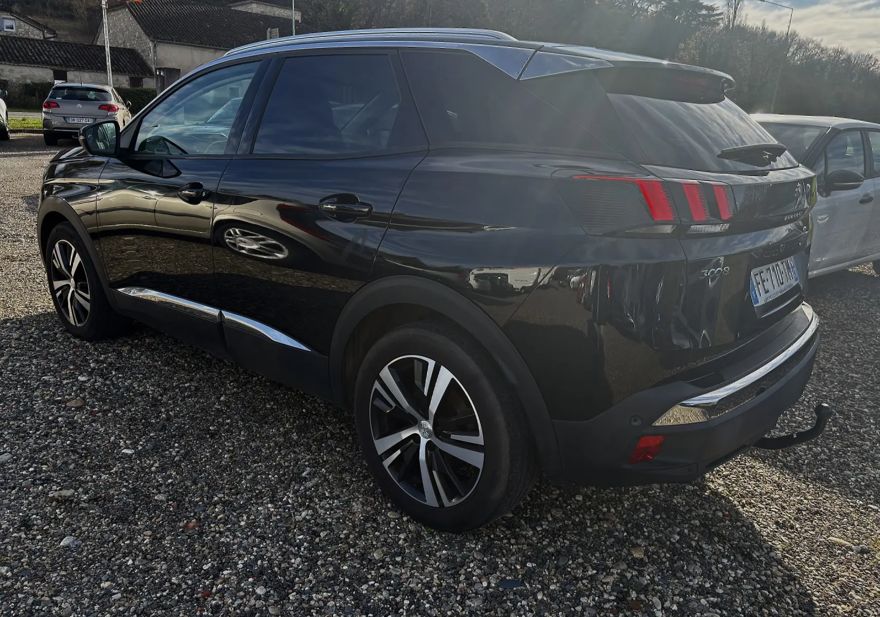 Vue 3/4 arrière droite d’un Peugeot 3008 noir 2019 avec feux arrière à griffes et attelage de remorque visible.