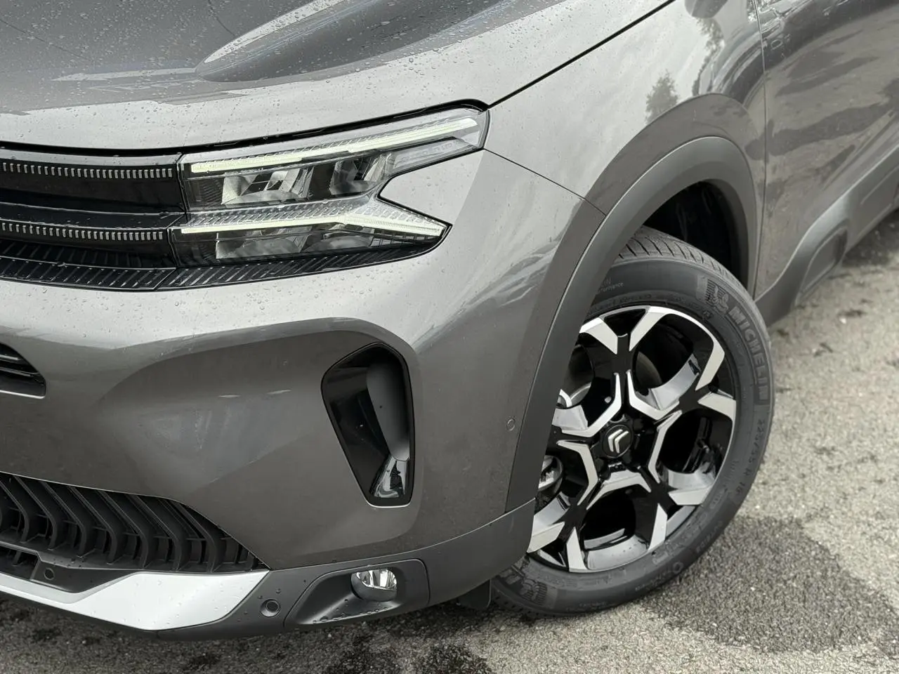 Gros plan sur l'avant droit gris Platinium du Citroën C5 Aircross 2025 avec phares LED et jante alliage 18'' bi-ton.