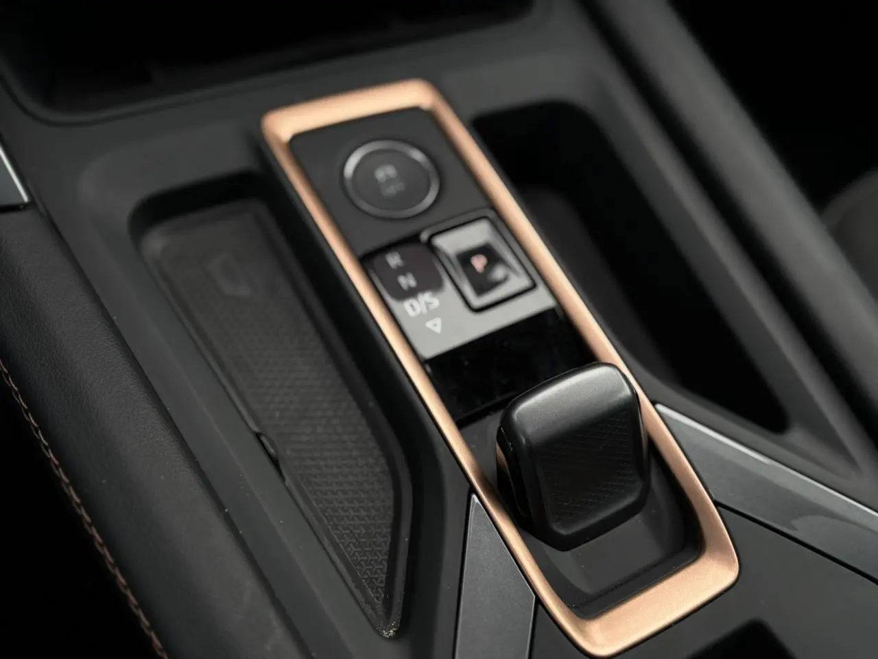 Gros plan sur la console centrale du CUPRA LEON ST 2025, mettant en valeur le levier de vitesses et les finitions cuivrées.