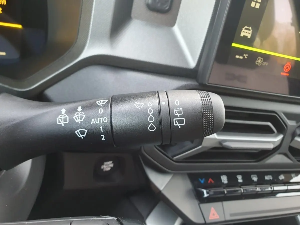 Gros plan sur la commande d’essuie-glace côté droit du tableau de bord du Dacia Bigster 2026 noir Perla.