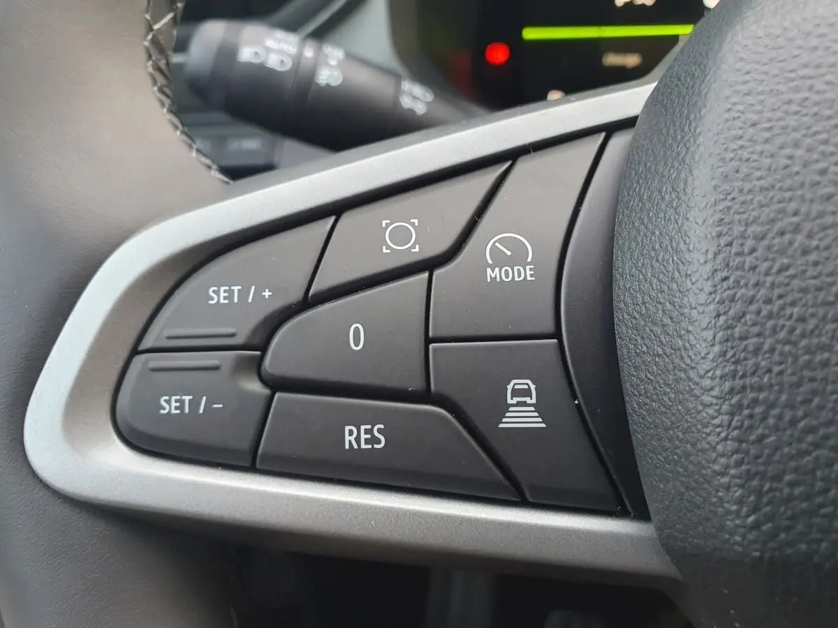 Gros plan sur les commandes au volant côté gauche du Dacia Bigster 2026 noir Perla, avec boutons de régulateur et mode conduite.