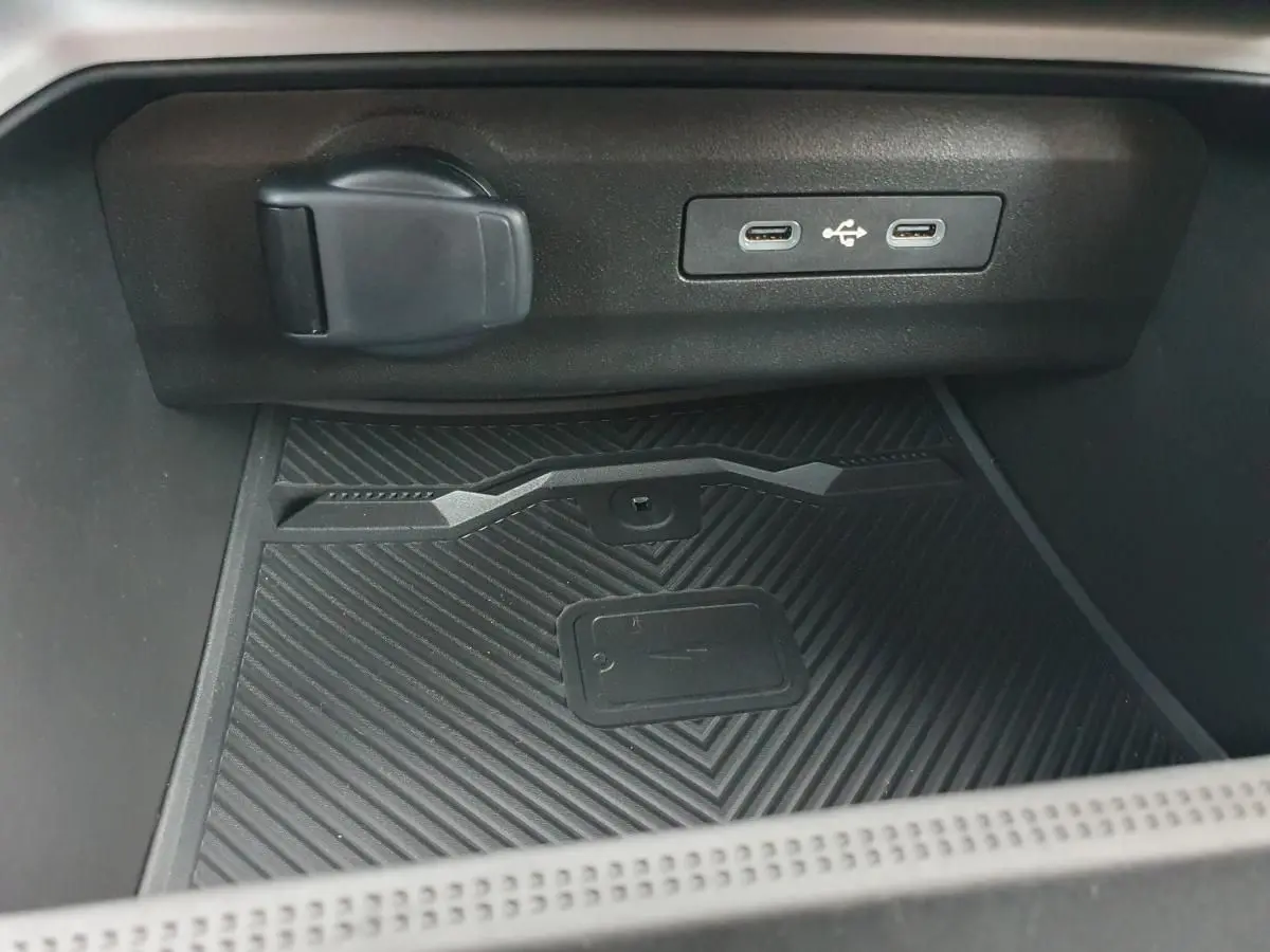 Gros plan sur la console centrale du Dacia Bigster noir Perla, montrant deux ports USB-C et un chargeur à induction.