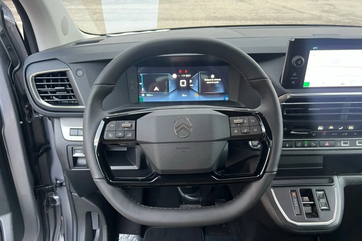 Vue intérieure centrée sur le volant cuir multifonctions et le tableau de bord numérique du Citroën Spacetourer gris acier.