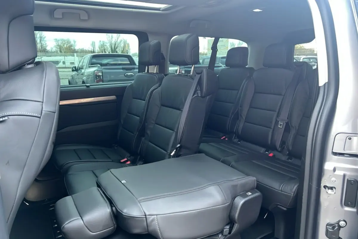 Intérieur du Citroën Spacetourer XL gris acier vu côté droit, sièges cuir noirs 8 places avec porte latérale ouverte.