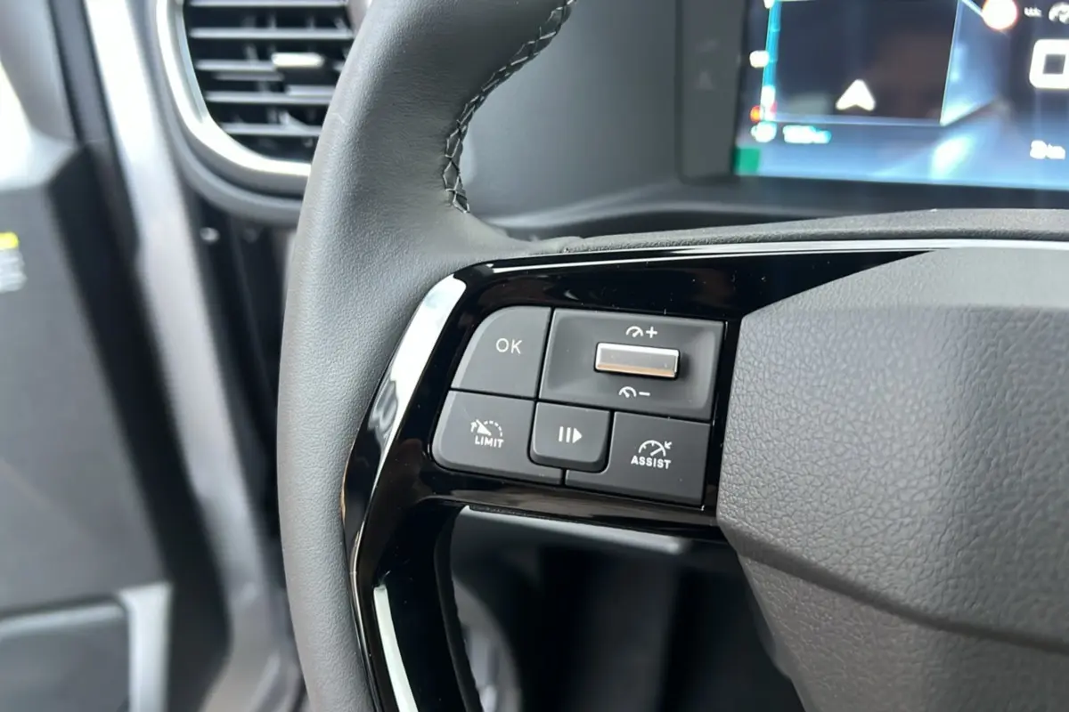 Gros plan sur les commandes multifonctions à gauche du volant cuir noir du Citroën Spacetourer gris acier 2025.