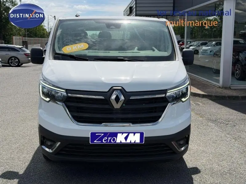 Vue de face d’un Renault Trafic Fourgon blanc Glacier 2024 avec calandre noire et phares LED allumés.