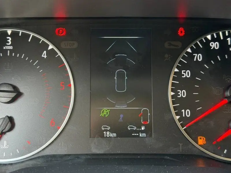 Tableau de bord du Renault Trafic Fourgon blanc, affichage central avec alertes et compteurs analogiques visibles.