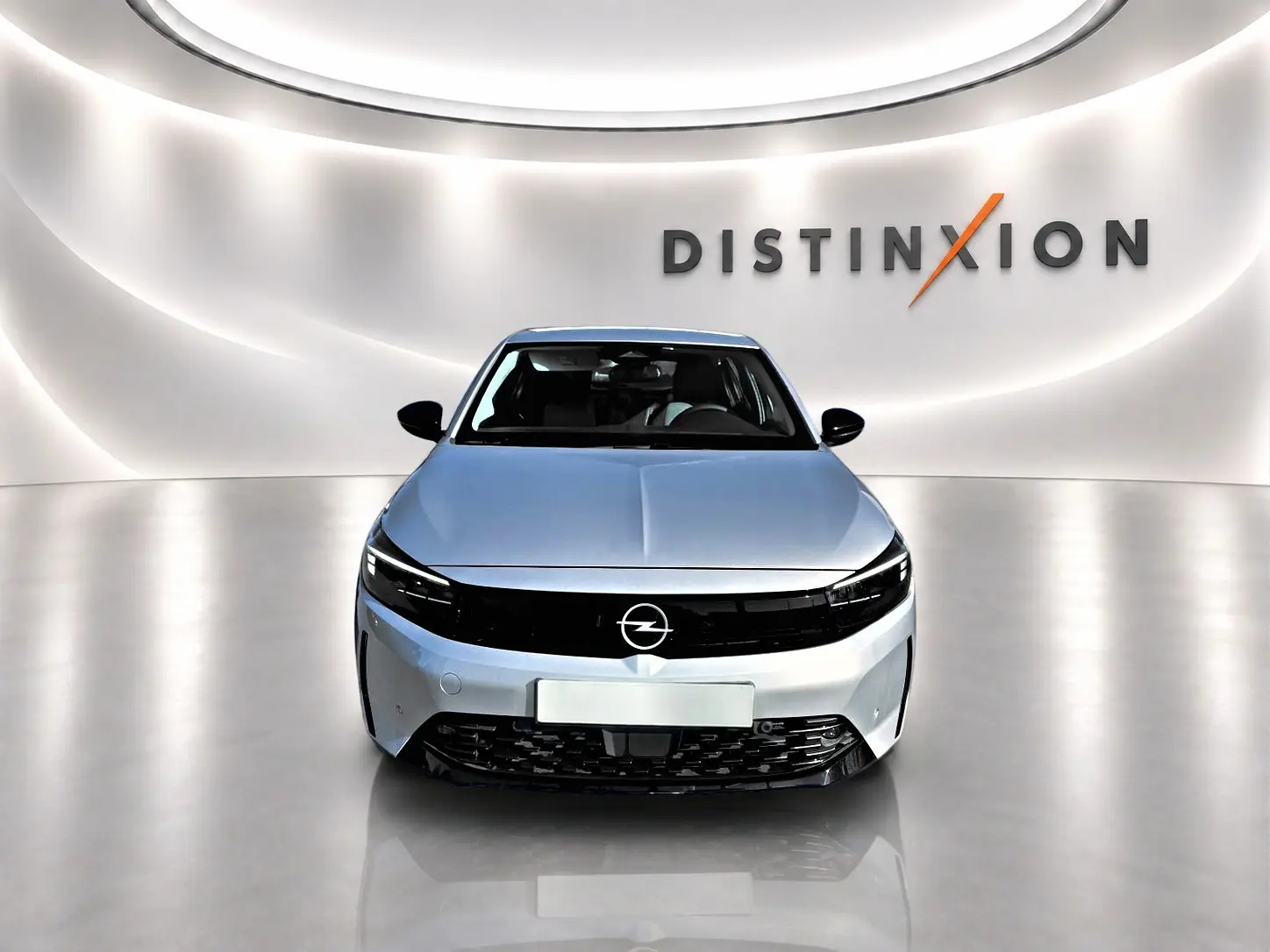 Vue avant d'une Opel Corsa gris clair avec calandre noire brillante, dans un showroom lumineux marqué Distinxion.