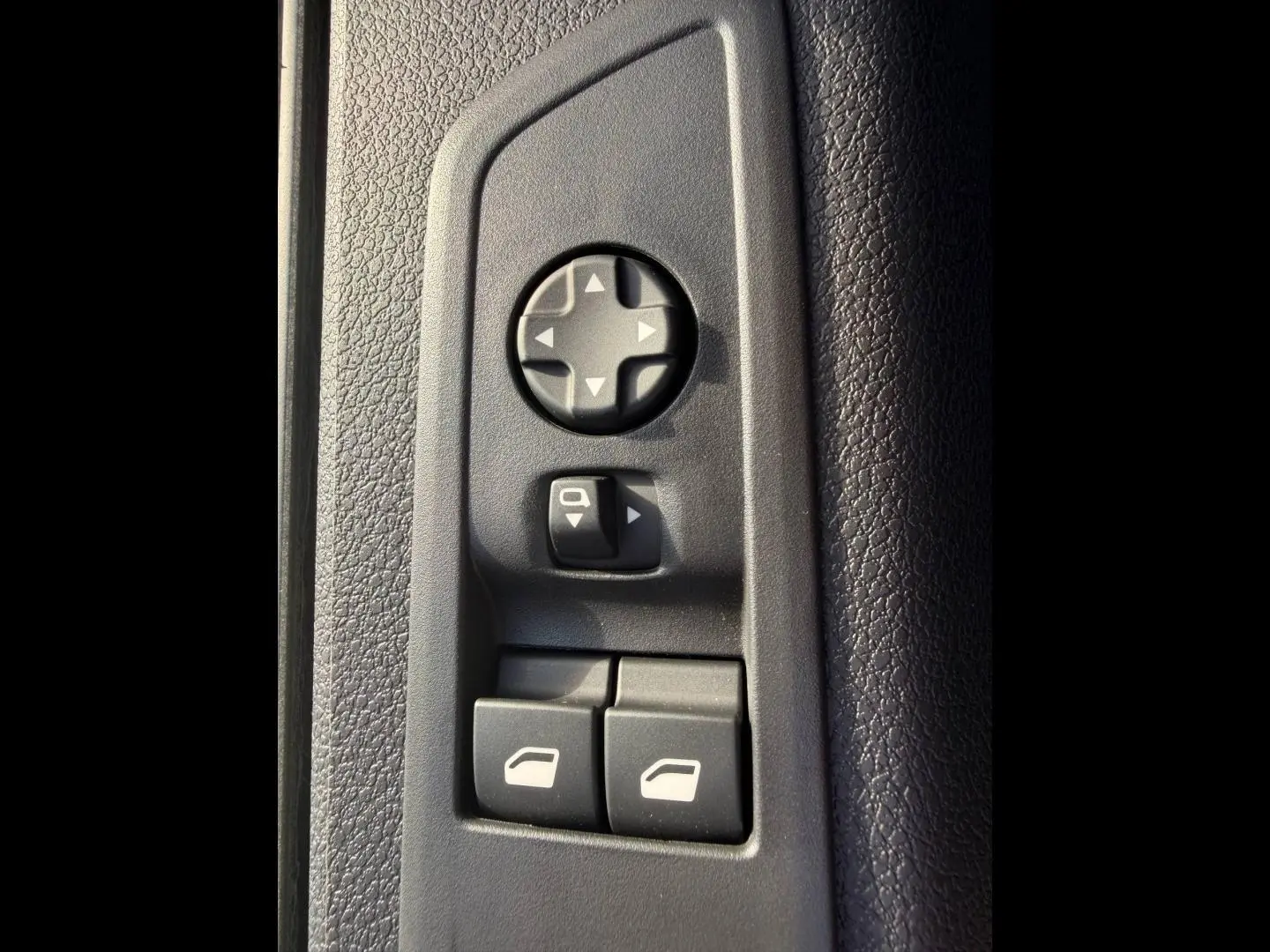 Gros plan sur les commandes de réglage des rétroviseurs et des vitres côté conducteur du Citroën Spacetourer noir.