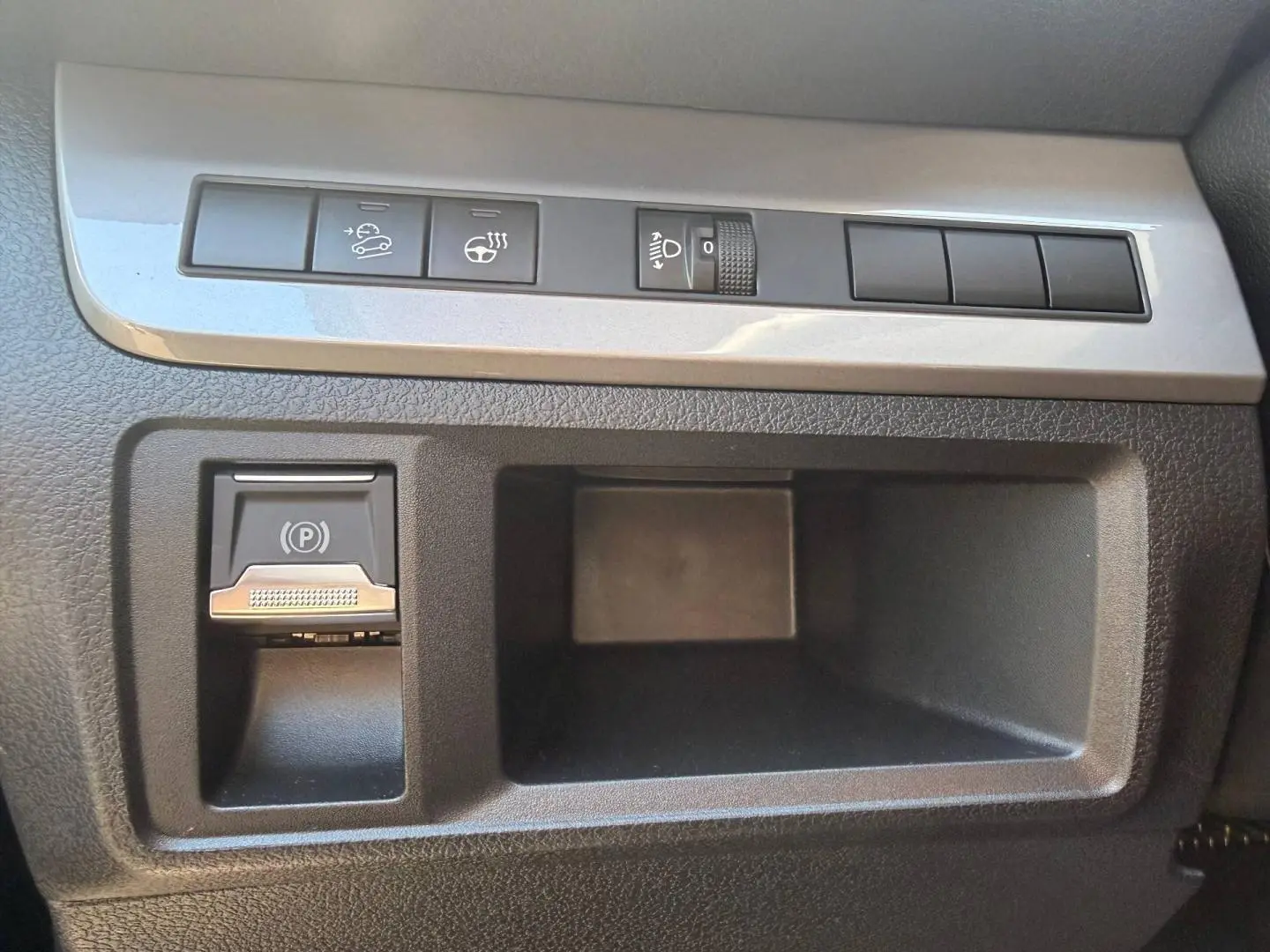 Gros plan sur les commandes de régulateur de vitesse et frein de stationnement électrique du tableau de bord du Citroën Spacetourer XL noir.