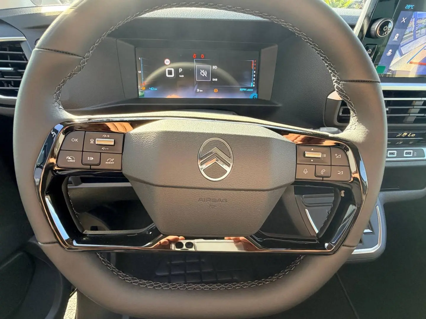 Vue rapprochée du volant noir mat de la Citroën Spacetourer avec commandes intégrées et tableau de bord numérique.