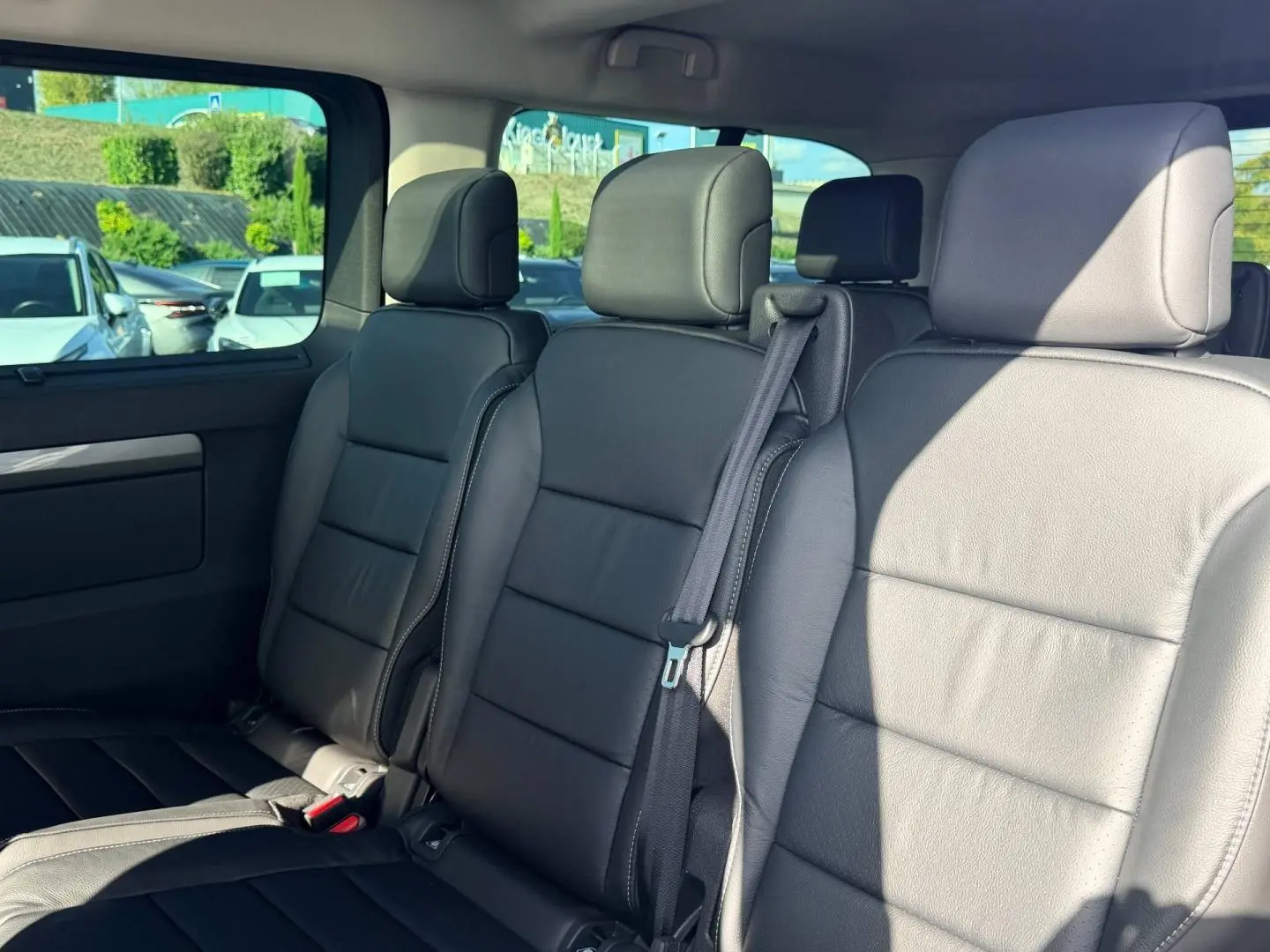 Vue intérieure sur la banquette arrière en cuir noir du Citroën Spacetourer XL, avec ceinture de sécurité visible.