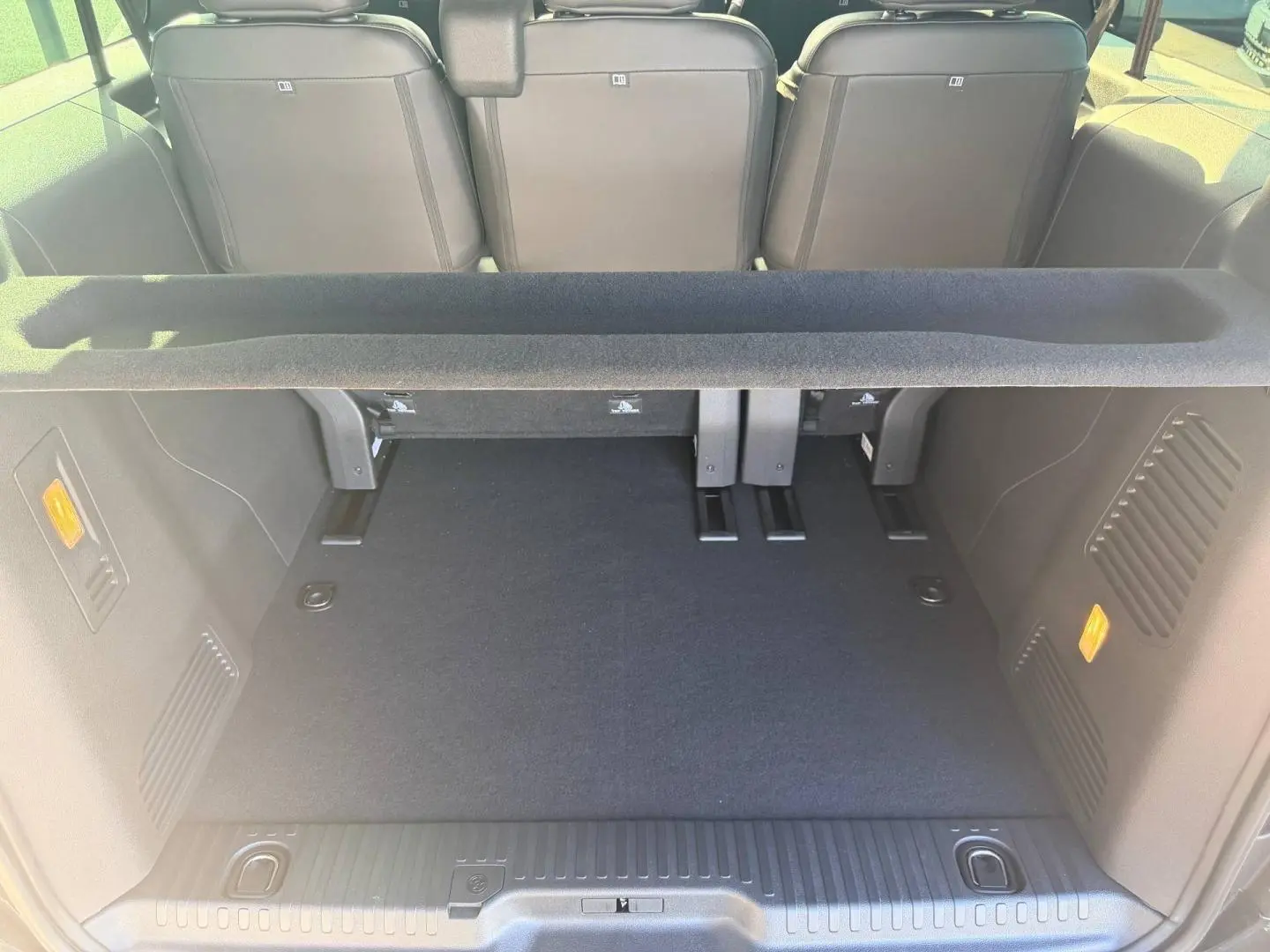 Coffre spacieux vu de l'arrière du Citroën Spacetourer XL noir Perla Nera avec banquette arrière relevée.