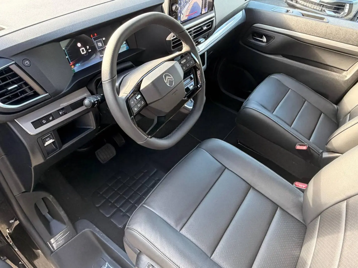 Vue intérieure côté conducteur du Citroën Spacetourer XL noir, avec volant multifonction et sièges en cuir noir.