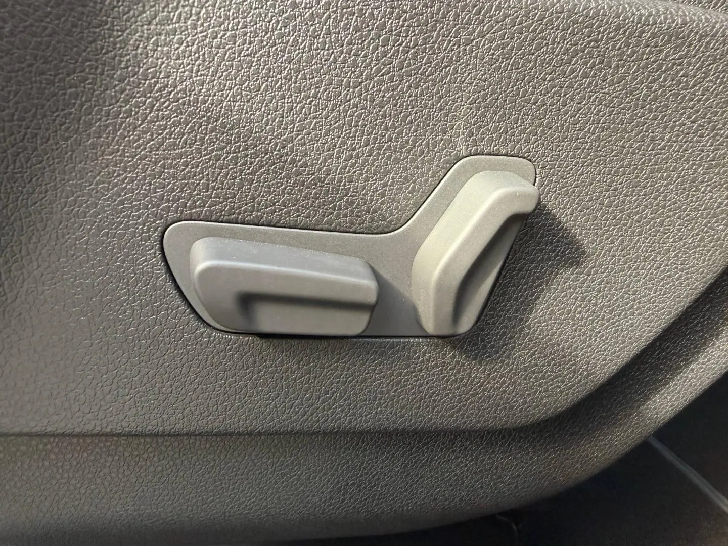 Gros plan sur les commandes de réglage manuel du siège côté conducteur du Citroën Spacetourer XL noir.