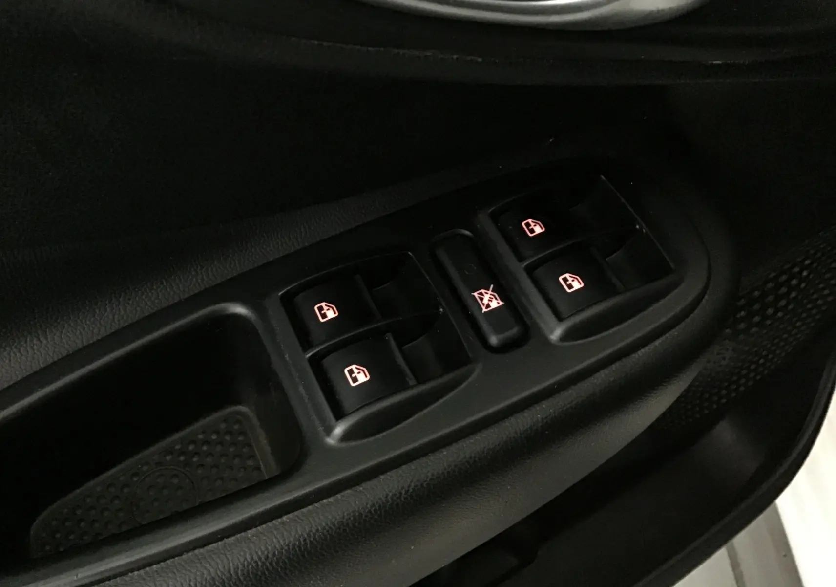 Gros plan sur les commandes des vitres électriques côté conducteur d'une FIAT 500L blanche de 2015.