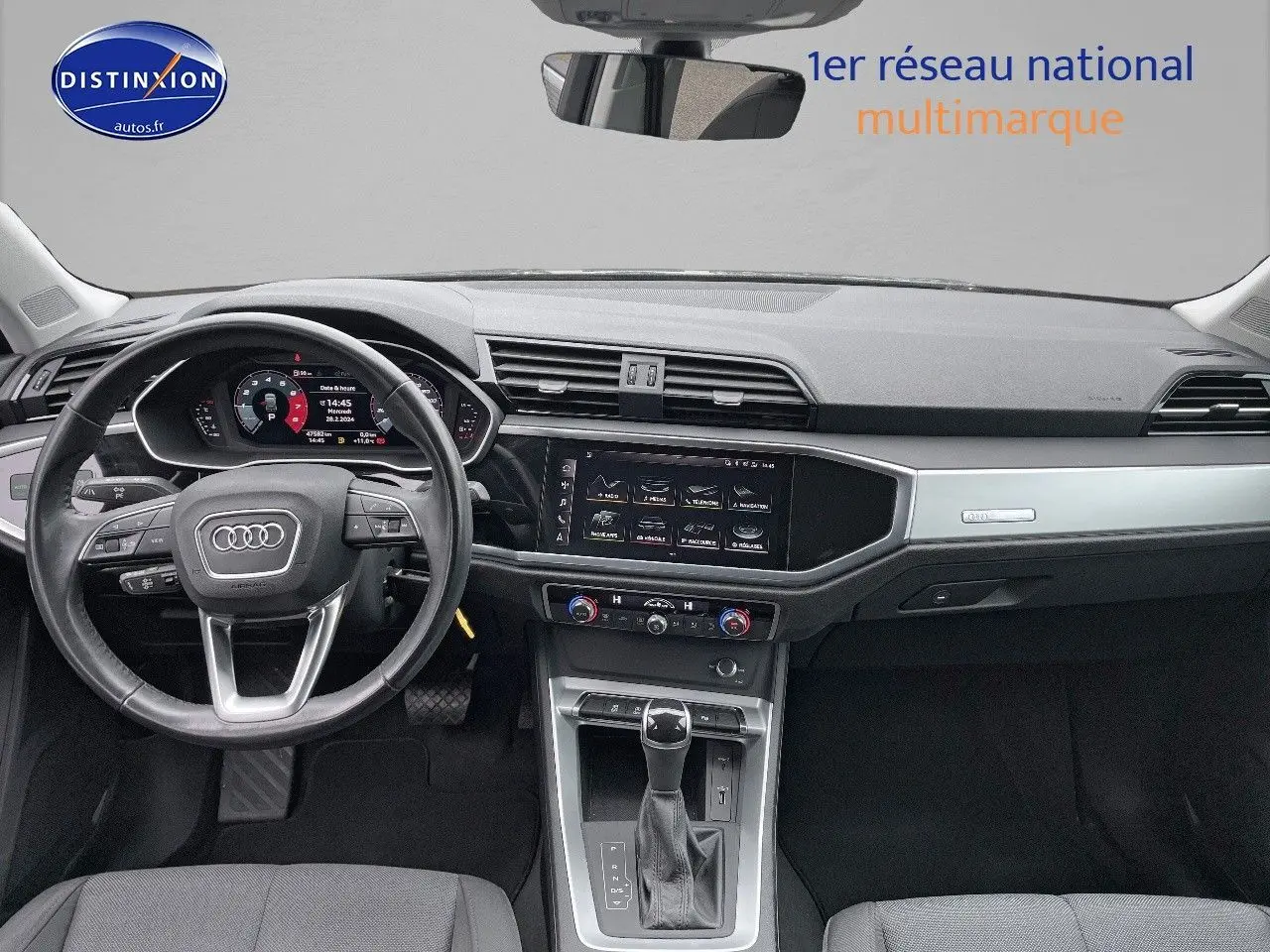 Vue intérieure avant de l'Audi Q3 35 TFSI 2019, tableau de bord moderne avec écran tactile et volant multifonction noir.