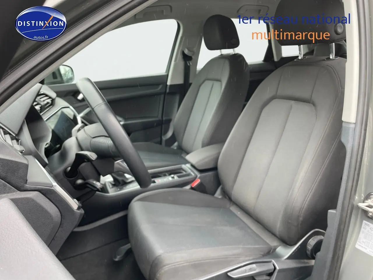 Vue intérieure côté conducteur de l'Audi Q3 35 TFSI 2019 avec sièges tissu gris et tableau de bord moderne.