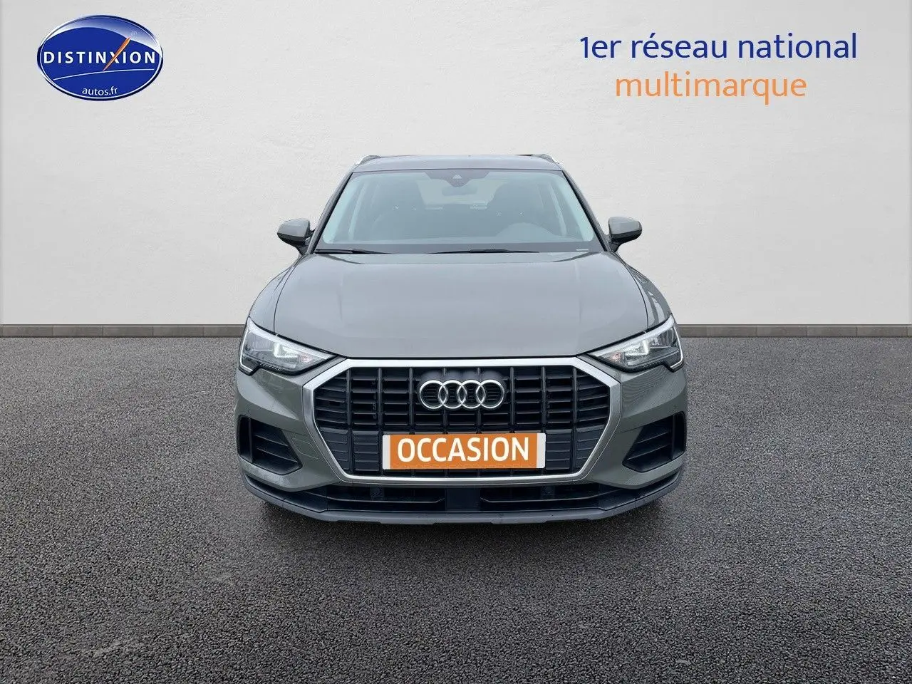 Audi Q3 35 TFSI gris chronos métal vu de face, mettant en valeur sa calandre hexagonale et ses phares LED distinctifs.