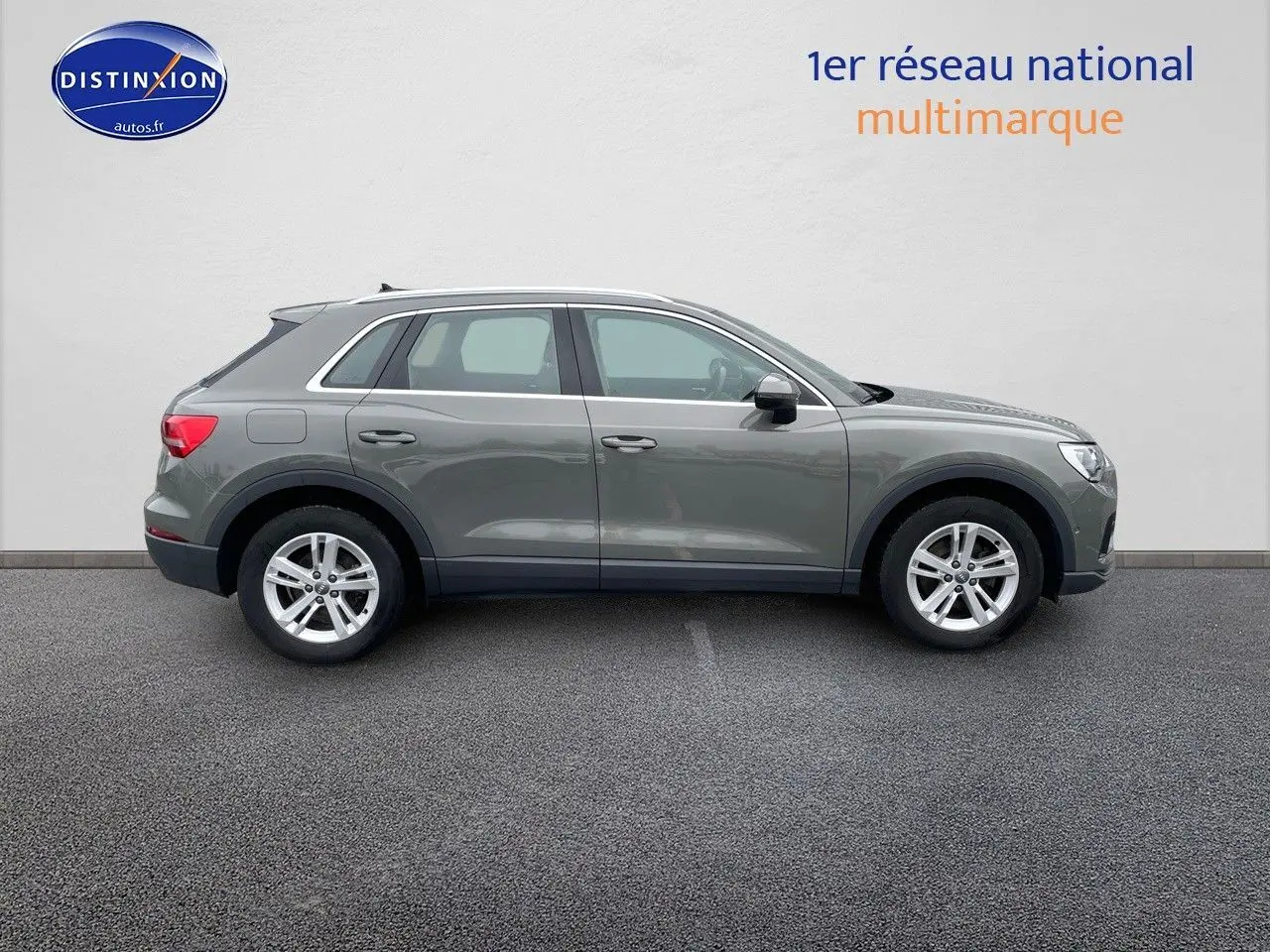 Audi Q3 gris chronos métal vu de profil côté gauche, avec jantes alliage et lignes épurées.