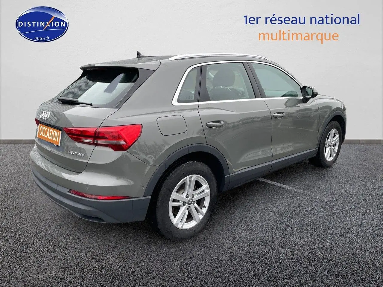 Audi Q3 gris Chronos métal vu en 3/4 arrière droit, soulignant ses feux arrière et jantes alliage.