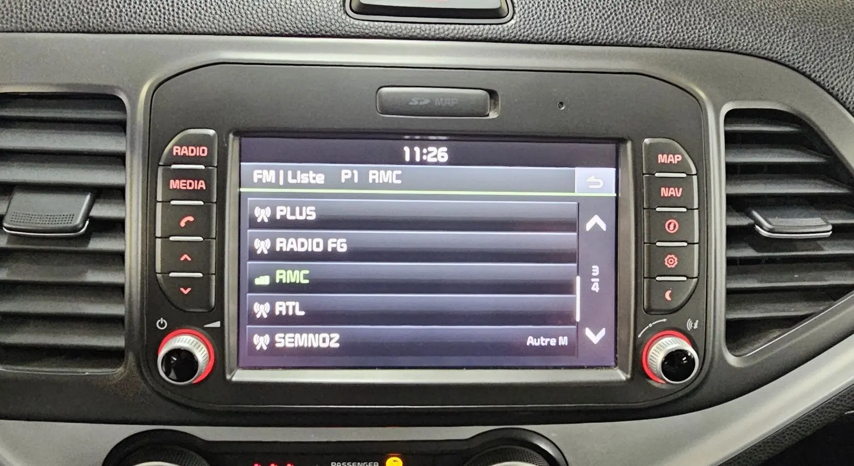 Écran central tactile de la Kia Picanto II 2016 affichant la liste des stations radio avec commandes autour.