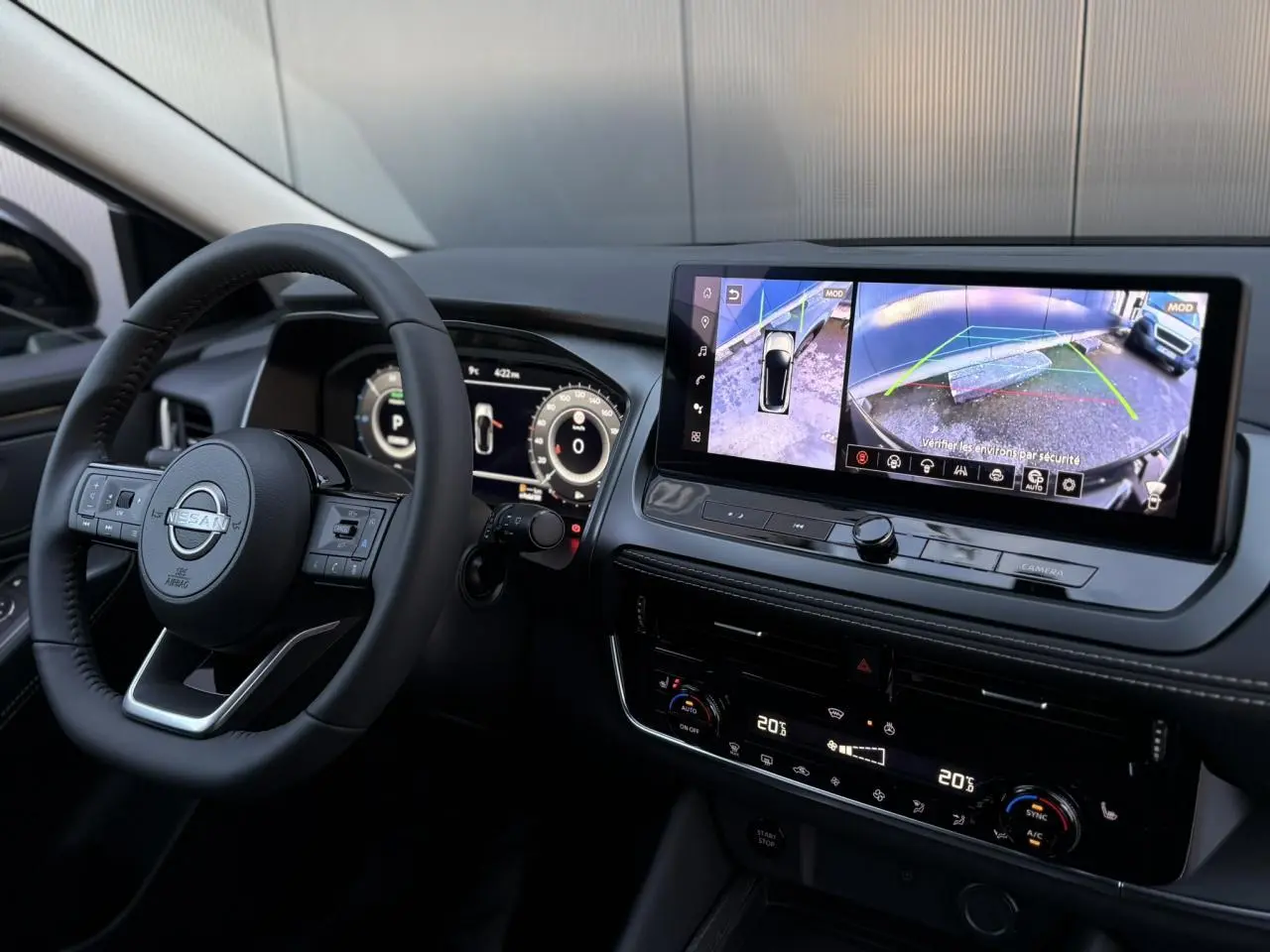 Vue intérieure du tableau de bord du Nissan Qashqai 2025, avec écran tactile affichant la caméra de recul et volant multifonction noir.