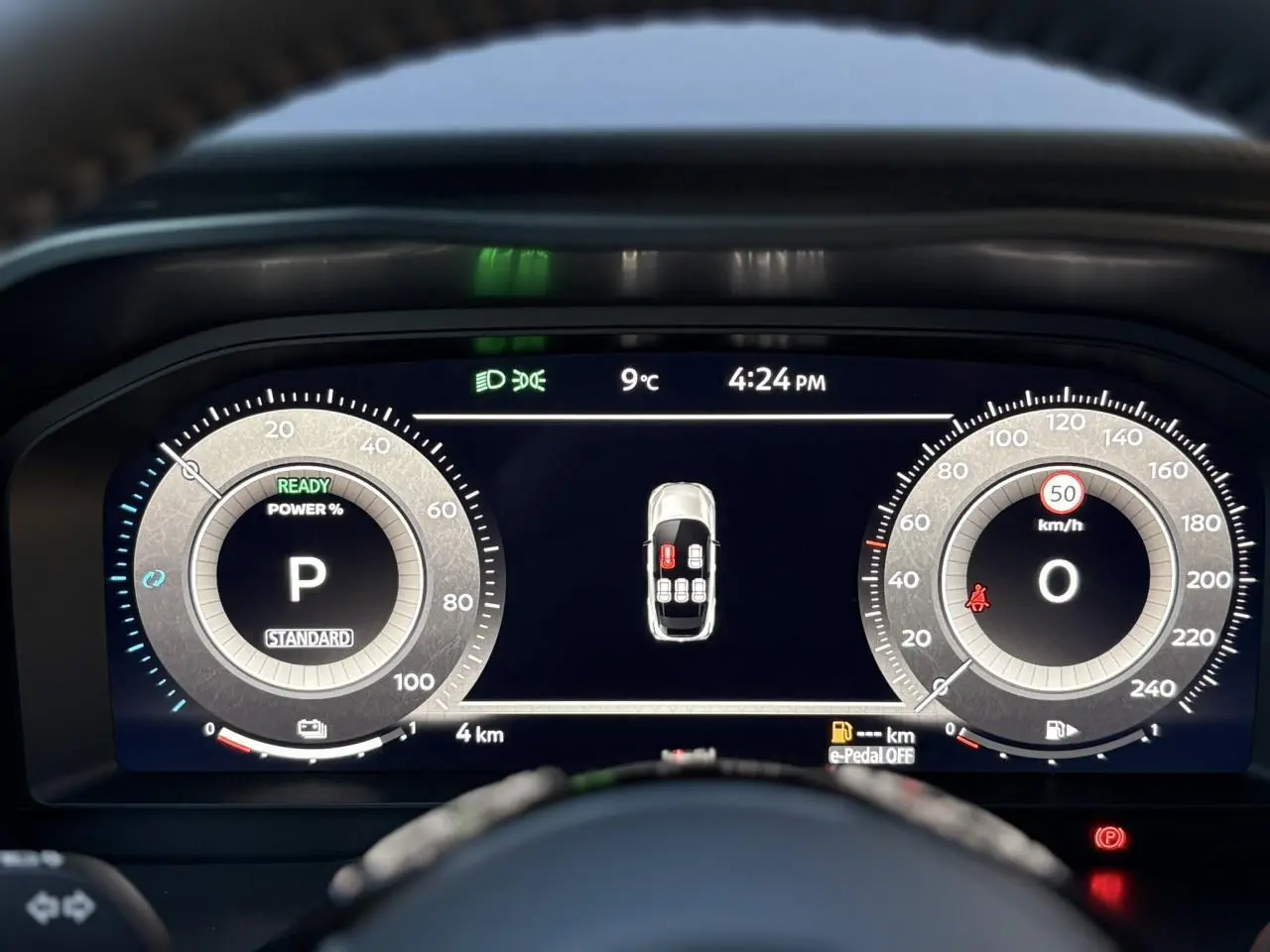 Affichage numérique du tableau de bord du Nissan Qashqai gris, montrant la vitesse à 0 km/h et l'heure à 16h24.