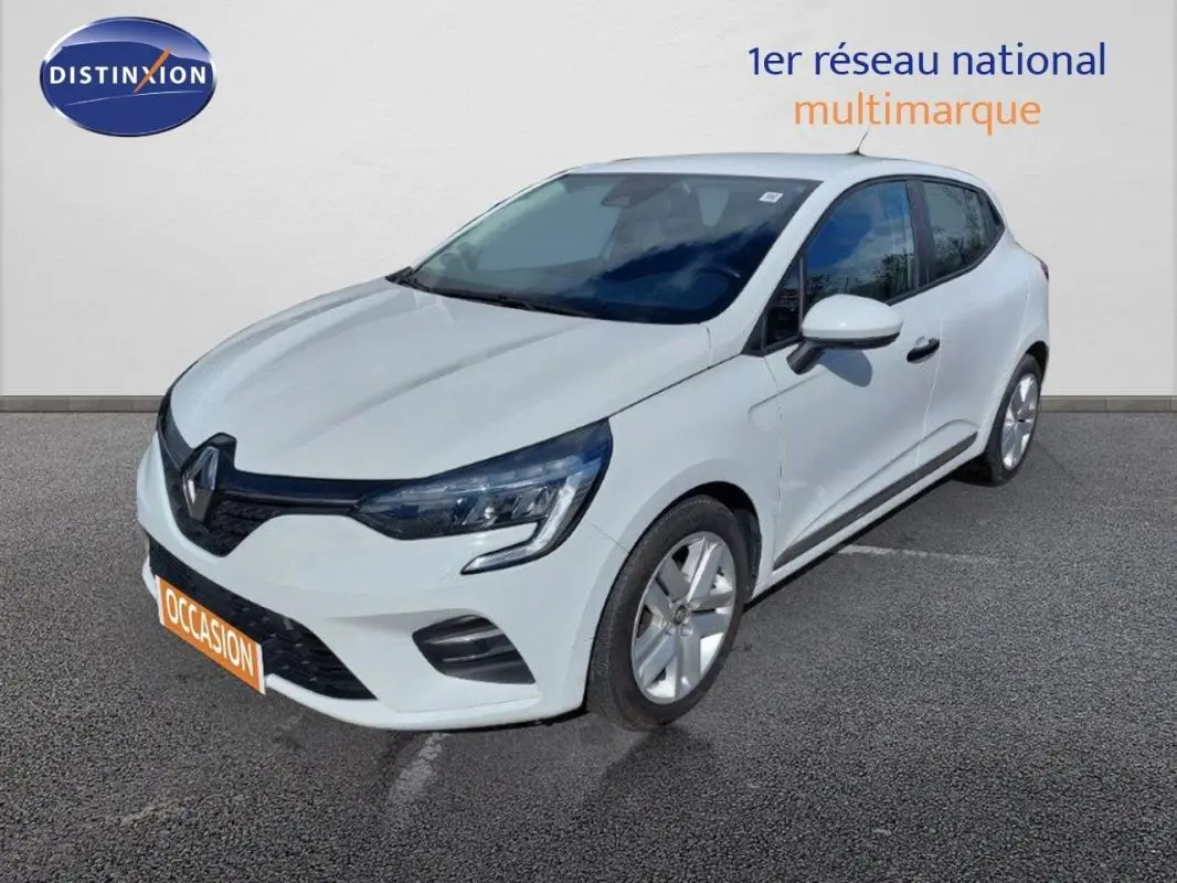 Renault Clio blanc vue 3/4 avant droit, avec feux LED et jantes alliage, stationnée sur sol gris.