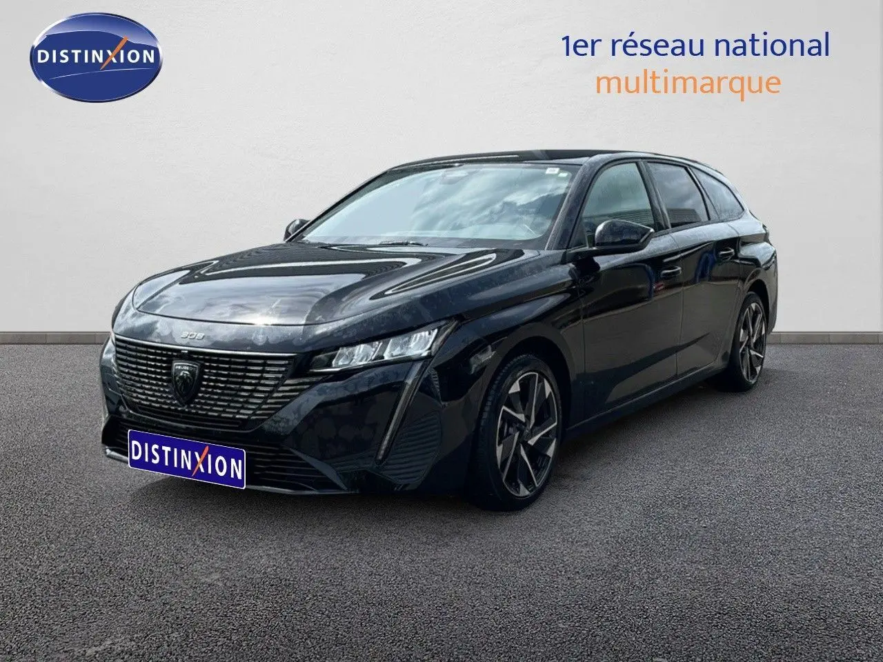 Peugeot 308 SW Hybrid noir métal en 3/4 avant droit, avec calandre distinctive et jantes alliage bicolores.