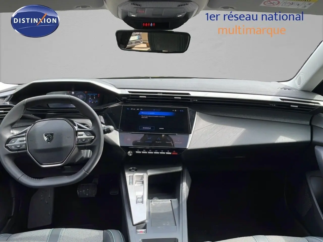 Vue intérieure avant du Peugeot 308 SW Hybrid 2025 avec tableau de bord noir et écran tactile central lumineux.