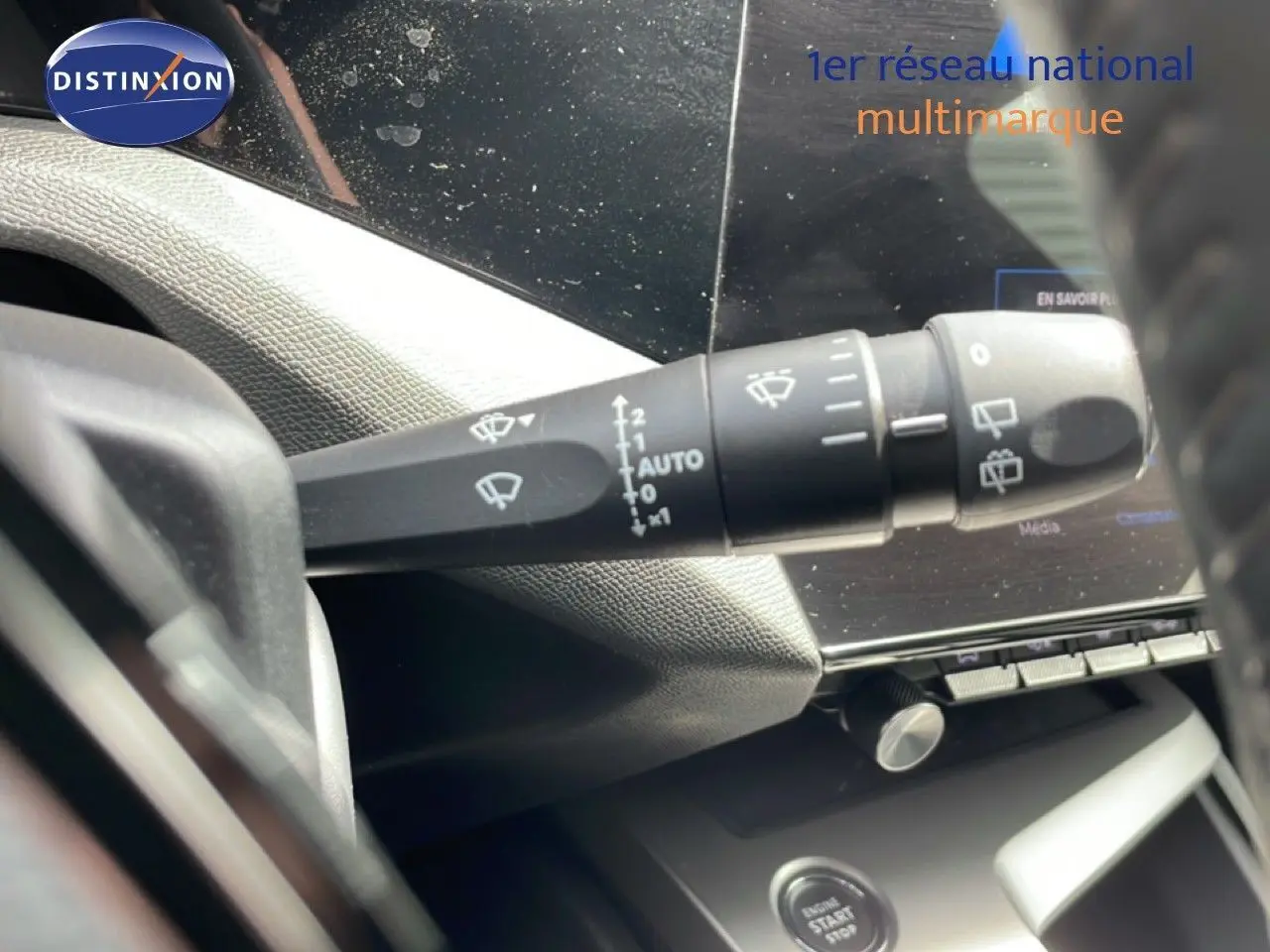 Gros plan sur la commande d’essuie-glace côté gauche du tableau de bord d’une Peugeot 308 SW noire 2025.