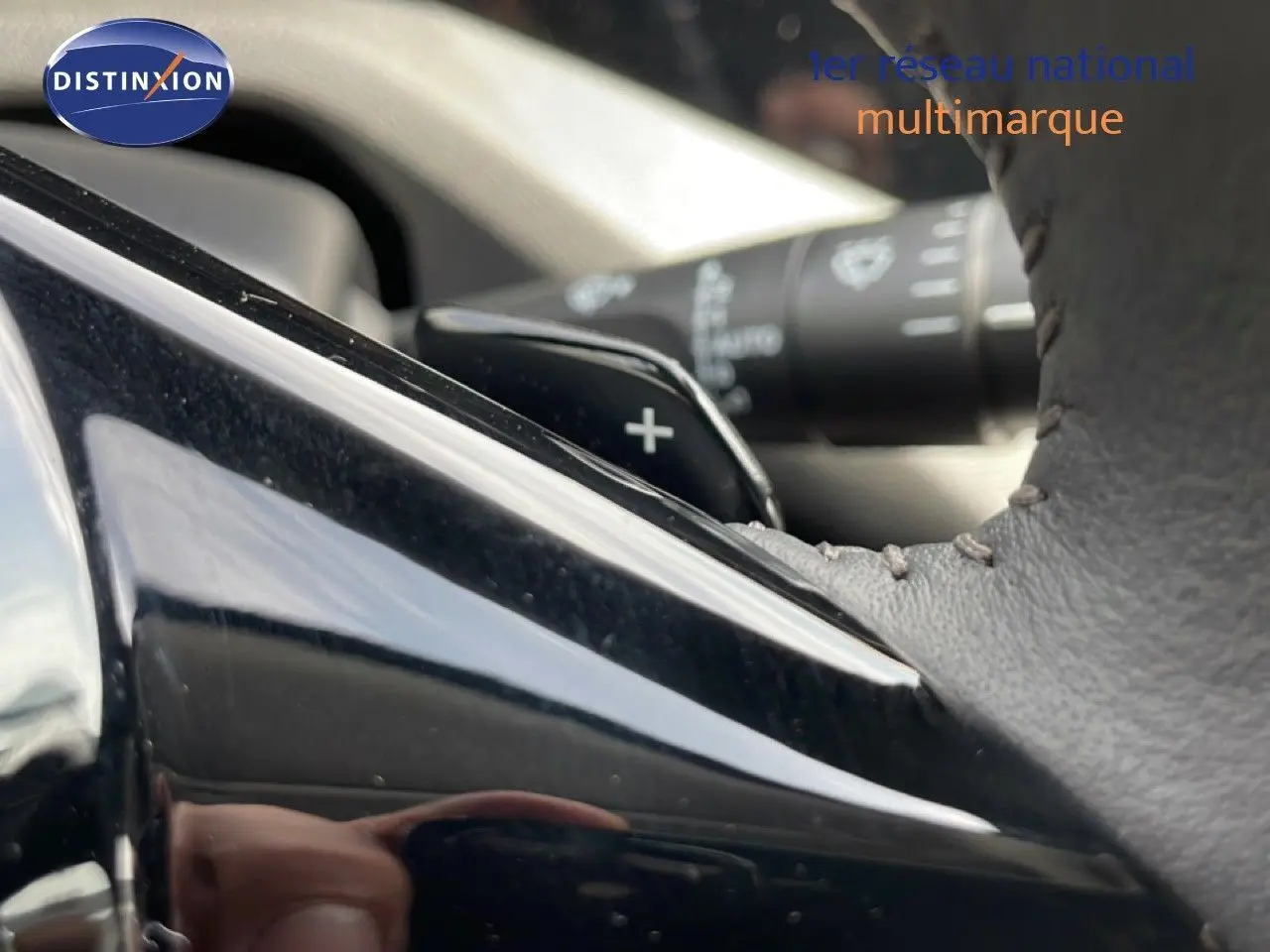 Détail du levier de vitesse automatique et du volant en cuir noir à surpiqûres dans une Peugeot 308 SW Hybrid 2025.