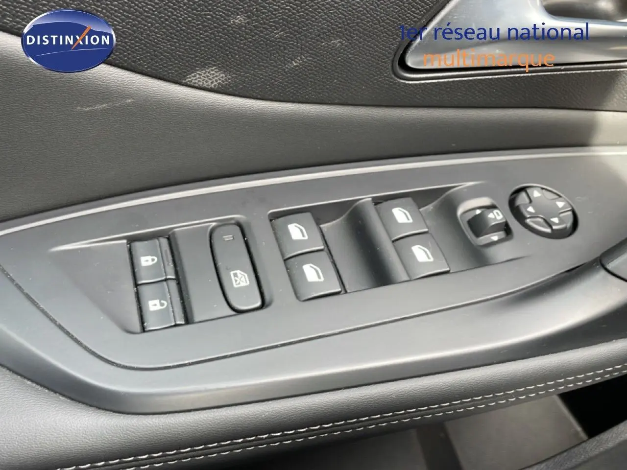 Gros plan sur les commandes de lève-vitres et rétroviseurs côté gauche intérieur d'une Peugeot 308 SW noir métal 2025.