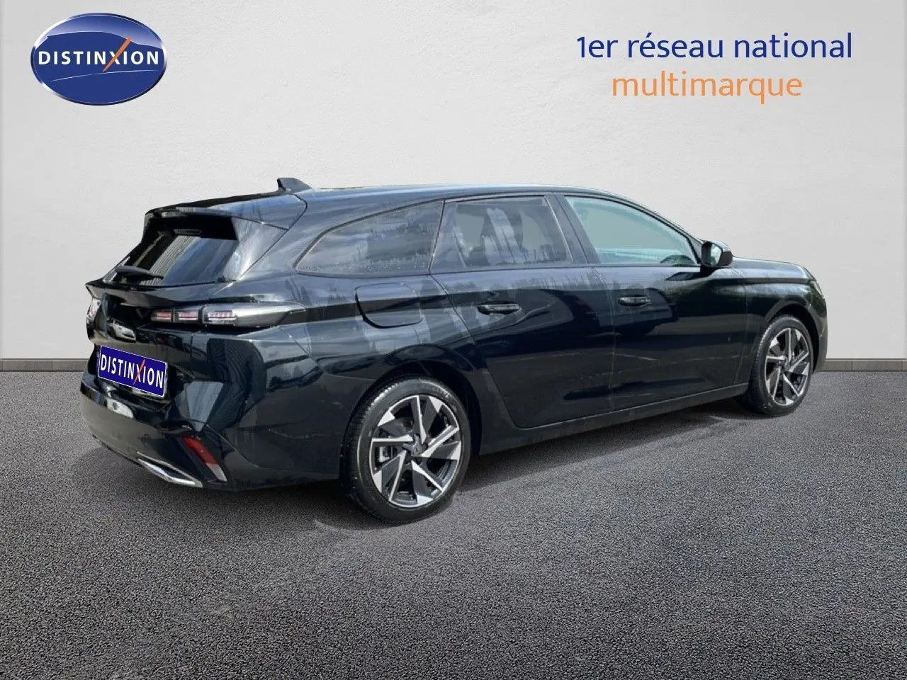 Peugeot 308 SW noir métal vue 3/4 arrière côté droit, avec jantes alliage et feux arrière LED distinctifs.